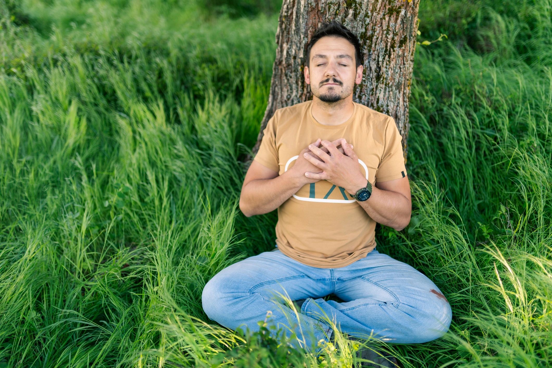 Person resting against a tree representing balanced lifestyle support