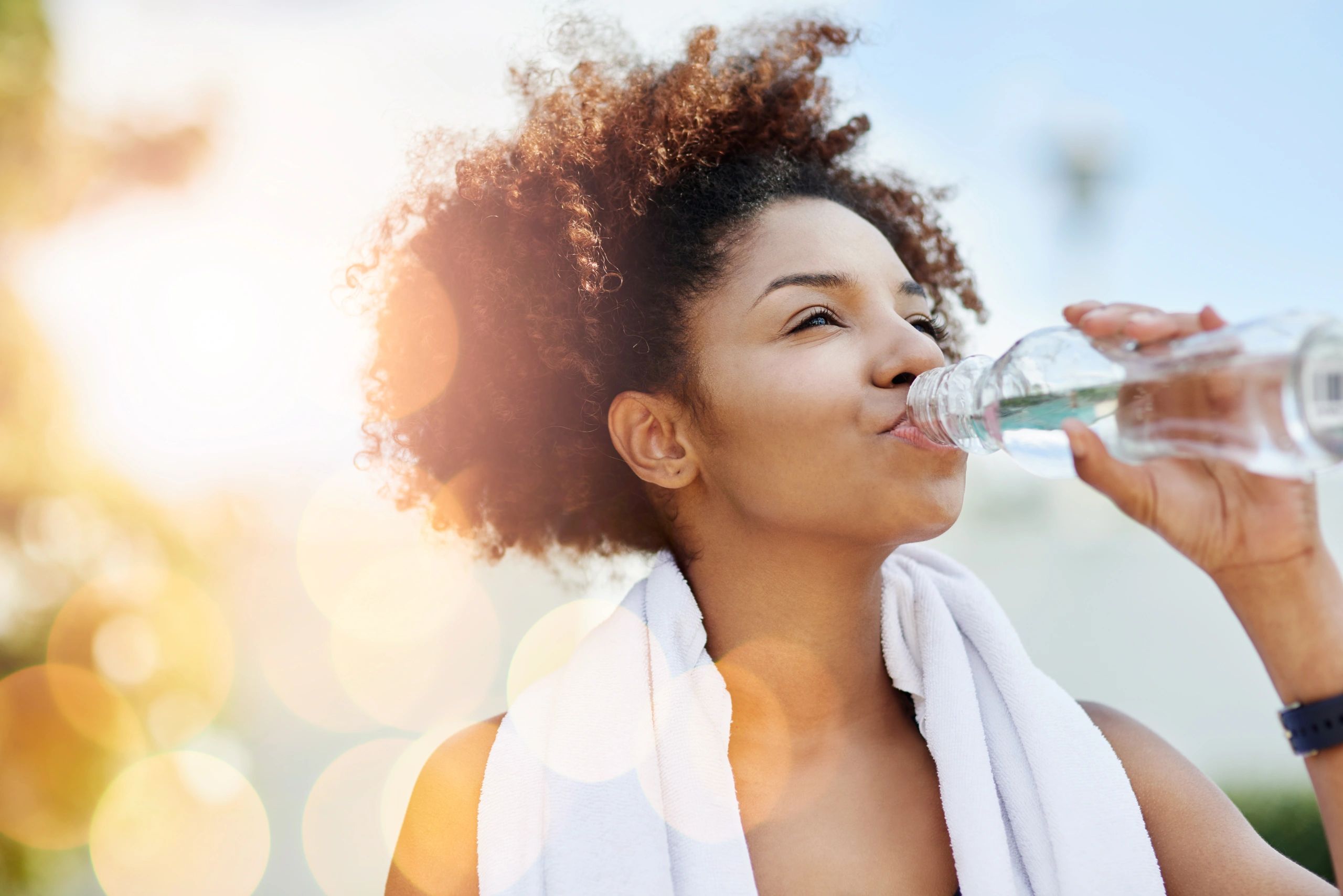 Woman drinking water after exercise as part of a healthy routine